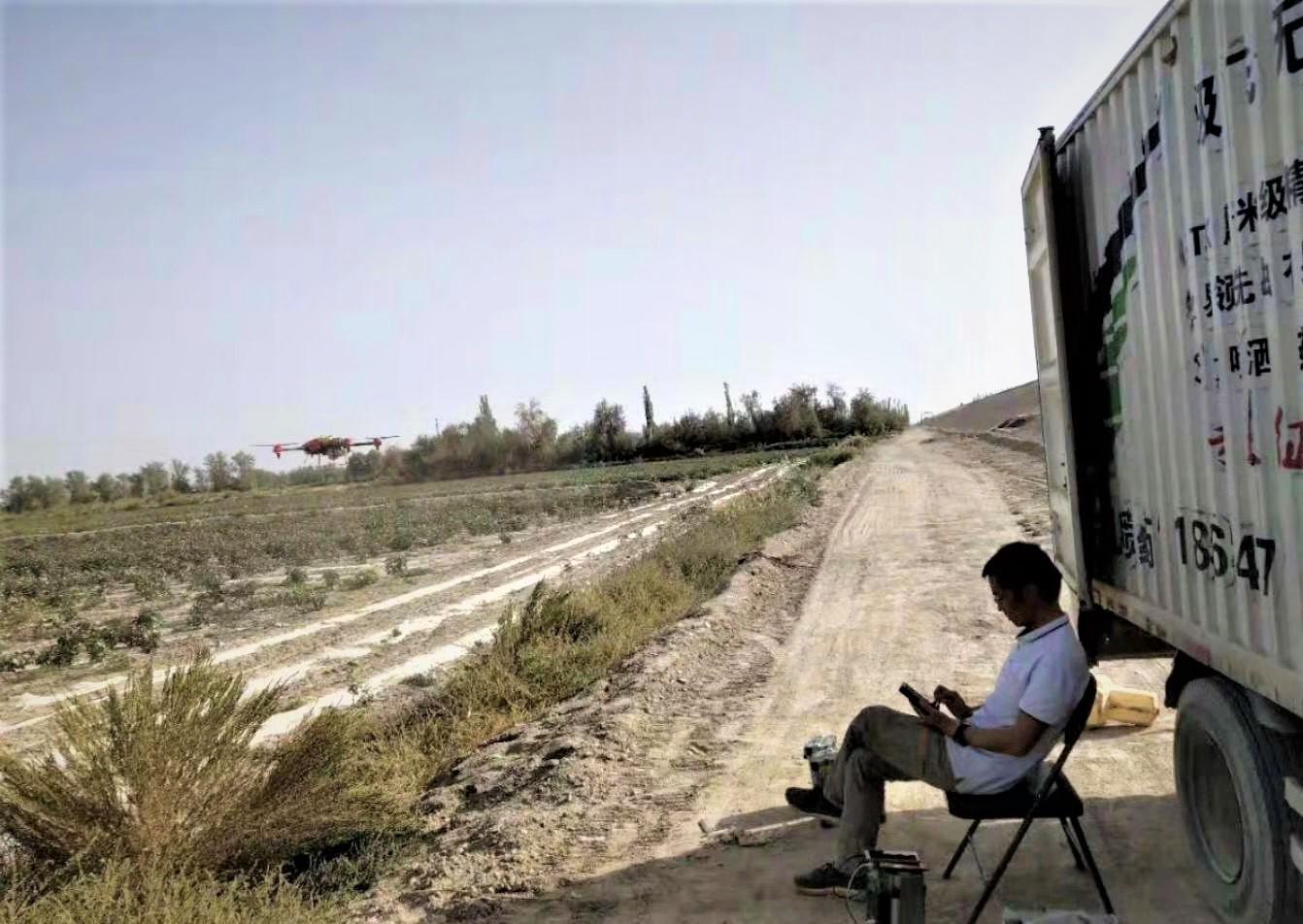 cheng sat by the truck, supervising the drone operation