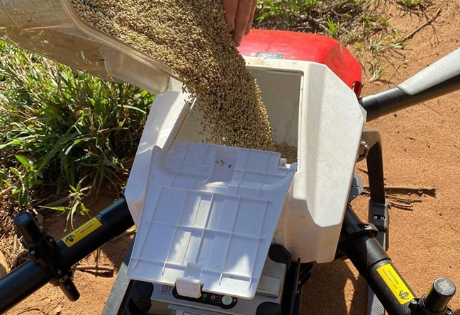 drone loaded with containers full of grass seeds