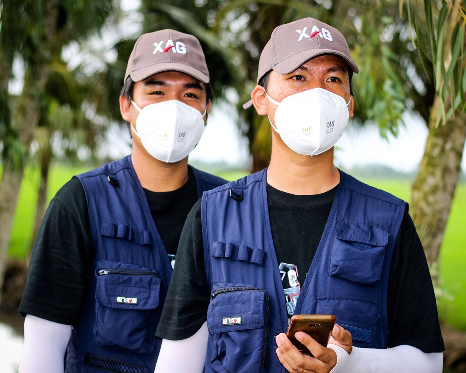 suit up with steady gaze at the nearby drones. as everything is ready, these two newbies of farming are now on the way to becoming skilled drone operators. 